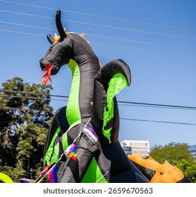 Large inflatable dragon with pride flags during outdoor city event