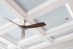 A Large Interior Fan On A Blue Coffered Ceiling