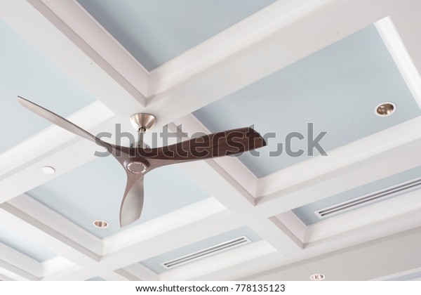 A Large\
Interior Fan on a Blue Coffered\
Ceiling