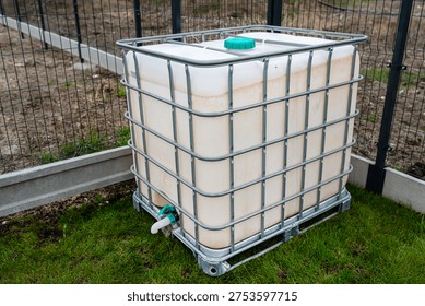 Large intermediate bulk container used for water storage in a fenced garden