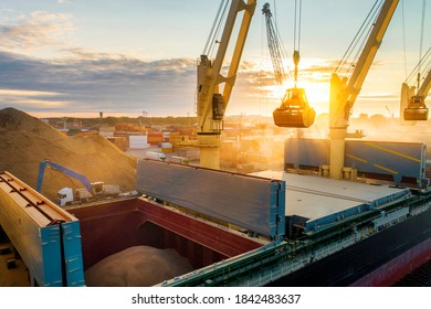 Large International Transportation Vessel In The Port, Loading Grain During Sunrise For Export In The Sea Waters.