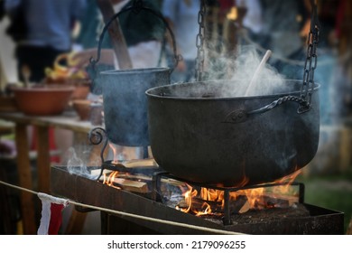 Large Iron Kettle Or Caldron With Steaming Stew Over Fire, Food For All On A Pristine Outdoor Feast, Selected Focus, Narrow Depth Of Field