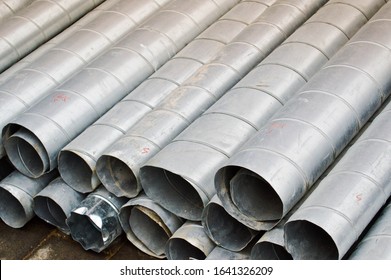 Large iron metal tin corrugated ventilation pipes of large diameter for the industrial construction of ventilation at a construction site during the repair.