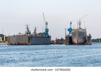 Large Iron Navy Ships In Shipyard For Repair. Big Crane In Dockyard. Blue Sea Harbor