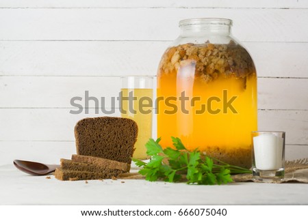 A large jar with kvass cooking. Black bread and a glass with a drink. Copy space.