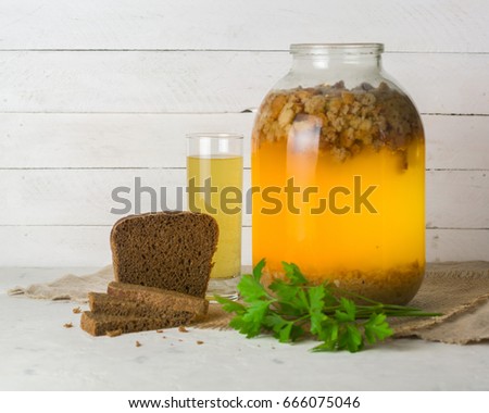 A large jar with kvass cooking. Black bread and a glass with a drink. Copy space.