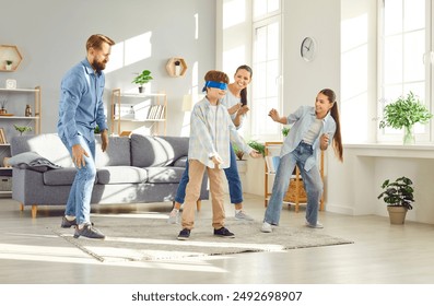 Large joyful family plays blindfolded games in living room. Children and parents participate in timeless games of blind man's buff game bringing light energy to family gathering Blind Man's buff game - Powered by Shutterstock