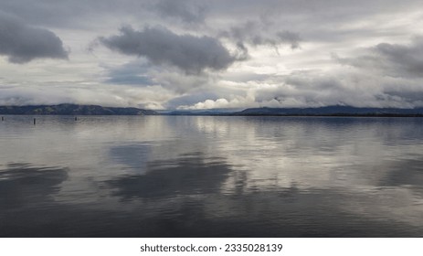 Large lake with clouds reflecting into the still water - Powered by Shutterstock