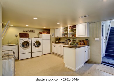 Large Laundry Room With Appliances And White Cabinets.