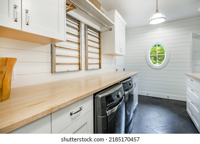 Large Laundry Room With Countertops Hangers Oval Window Concrete Stone Floor