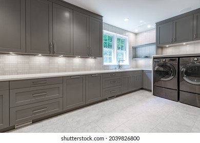 large laundry room with long counter grey cabinets and under cabinet lighting - Shutterstock ID 2039826800