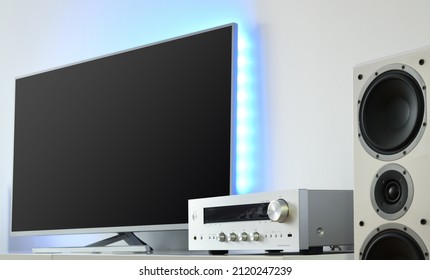 Large LED TV With Backlight And Audio Receiver In A Modern Apartment. 