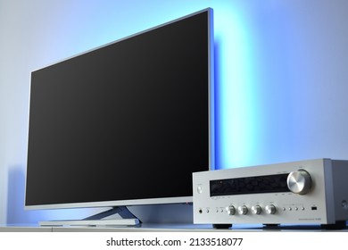 Large LED TV With Backlight And Audio Receiver In A Modern Apartment. 