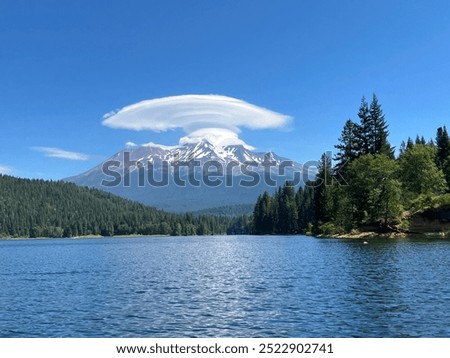 A large lenticular cloud over Mount Shasta in an otherwise deep blue sky