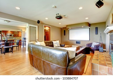 Large Living Room With Brown Walls And Leather Sofa With Projector Screen.