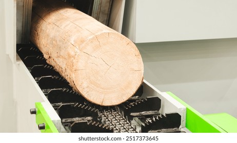 A large log is being processed by a machine. The machine is green and black. The log is being cut into smaller pieces