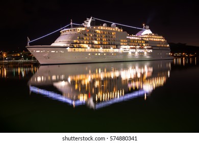 Large Luxury Cruise Ship On Sea Water At Night With Illuminated Light Docked At Port Of St.Johns, Antigua