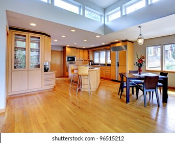 Large Luxury Modern Wood Kitchen With Granite Counter Tops And Yellow Hardwood Floor.