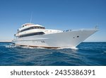 A large luxury private motor yacht under way sailing on tropical sea with bow wave