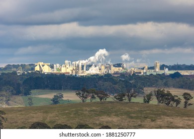 A Large Manufacturing Facility In A Regional Township With Steam Coming From The Chimney Stacks During Processing