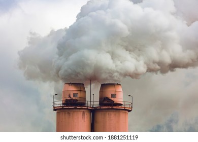 A Large Manufacturing Facility In A Regional Township With Steam Coming From The Chimney Stacks During Processing