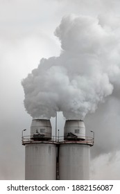 A Large Manufacturing Facility In A Regional Township With Steam Coming From The Chimney Stacks During Processing