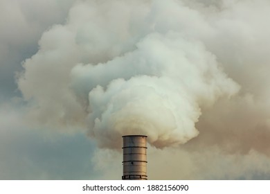 A Large Manufacturing Facility In A Regional Township With Steam Coming From The Chimney Stacks During Processing