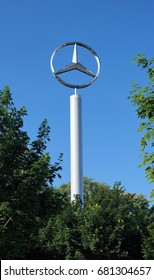 Large Mercedes-Benz Logo. Brussels, Belgium – June 2, 2017.  A tall Mercedes-Benz sign with the recognizable brand emblem stands above the trees at a dealership outside of Brussels - Shutterstock ID 681304657
