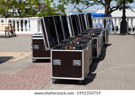 Large metal boxes with professional concert or musical equipment. Preparing for a mass event on city street. Transportation of sound equipment.