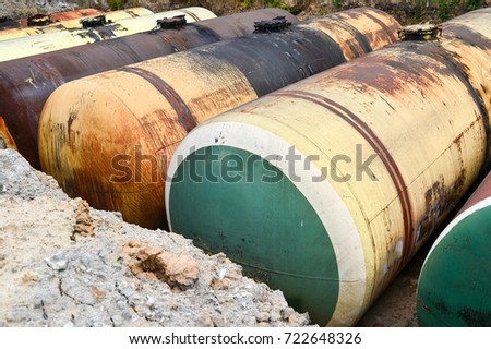 Large metal tanks are buried in the ground in the production warehouse.