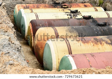 Large metal tanks are buried in the ground in the production warehouse.