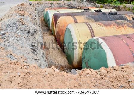 Large metal tanks are buried in the ground in the production warehouse