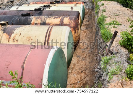 Large metal tanks are buried in the ground in the production warehouse