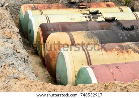 Large metal tanks are buried in the ground in the production warehouse.
