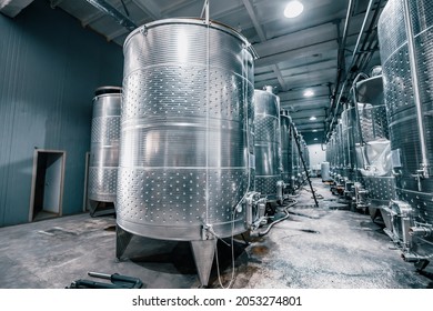 Large metal vats in which wine or beer is fermented at the factory at the winery. Concept of technologies and equipment for the production of alcoholic beverages