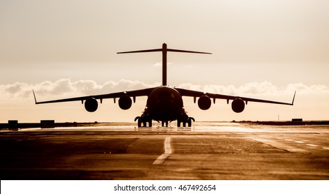 Large Military Cargo Plane Silhouette On An Empty Airstrip