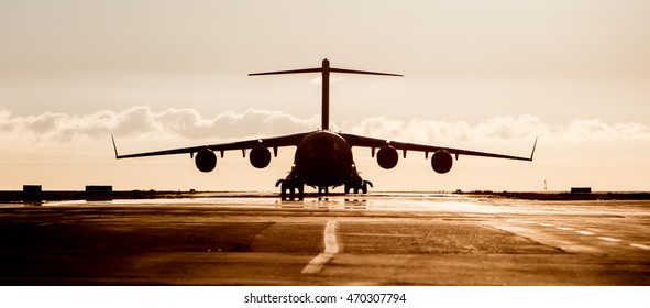 Large Military Cargo Plane Silhouette On An Empty Airstrip