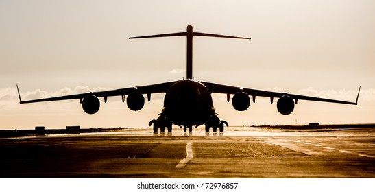 Large Military Cargo Plane Silhouette On An Empty Airstrip