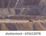 Large mining truck carrying ore across an open pit mine