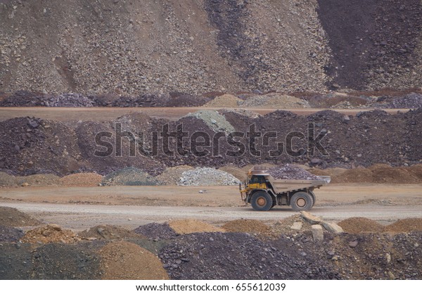 Large\
mining truck carrying ore across an open pit\
mine