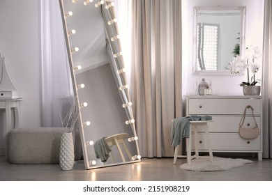 Large Mirror With Light Bulbs And Chest Of Drawers In Stylish Room. Interior Design