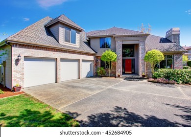 Large Modern House With Three Garage Spaces And Concrete Driveway. View Of High Ceiling Porch With Brick Walls