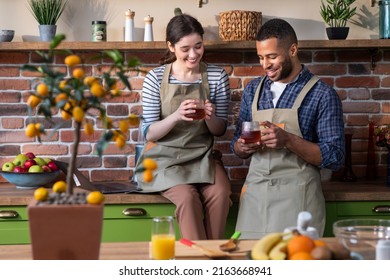 Large Modern Kitchen Happy Woman Using Laptop To Work While Her Husband Brings A Good Hot Tea And They Take The Break Together And Drink Some Tasty Tea