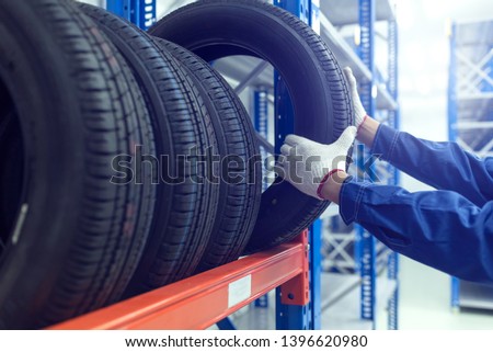 Large modern warehouse with forklifts and stack of car tires