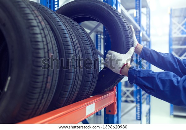 Large modern warehouse with forklifts and stack of\
car tires