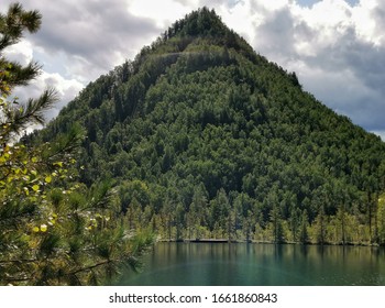 A Large Mountain Similar To An Equilateral Triangle On The Shores Of An Emerald Lake