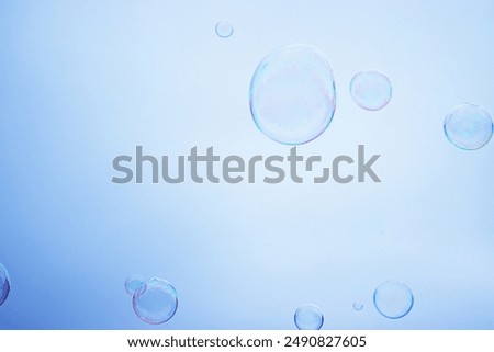 Large multicolored soap bubbles flying in the cloudy sky. Big bubble outdoors in the spring or summer street. Many bubbles isolated on white background. Simple creative concept. Close-up. Copy space