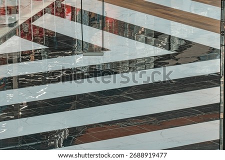 Large, multi-paned window on a modern building facade, reflecting dynamic colors and shapes Intricate, diagonal geometric pattern Surroundings suggest similar textures and materials