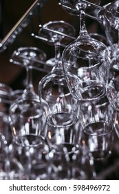 A large number of empty wine glasses hung over the bar counter
