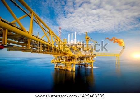 Large Offshore oil rig drilling platform at sunset and beautiful sky in the gulf of Thailand